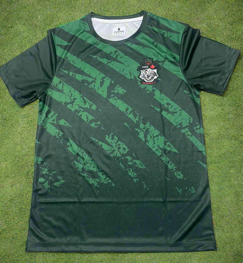 Green sports jersey with a logo on a light brown surface