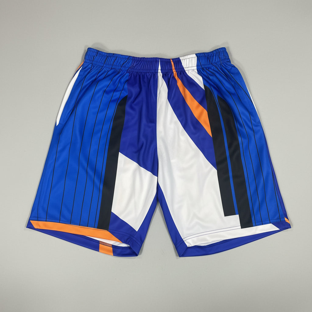 Colorful athletic shorts with blue, white, and orange design on a concrete floor.