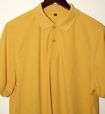 Yellow polo shirt on a hanger against a white background