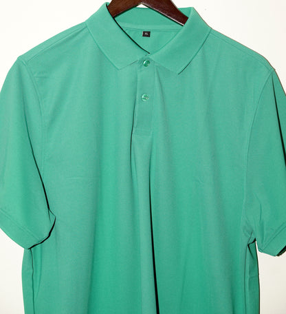 Green polo shirt on a hanger against a white background