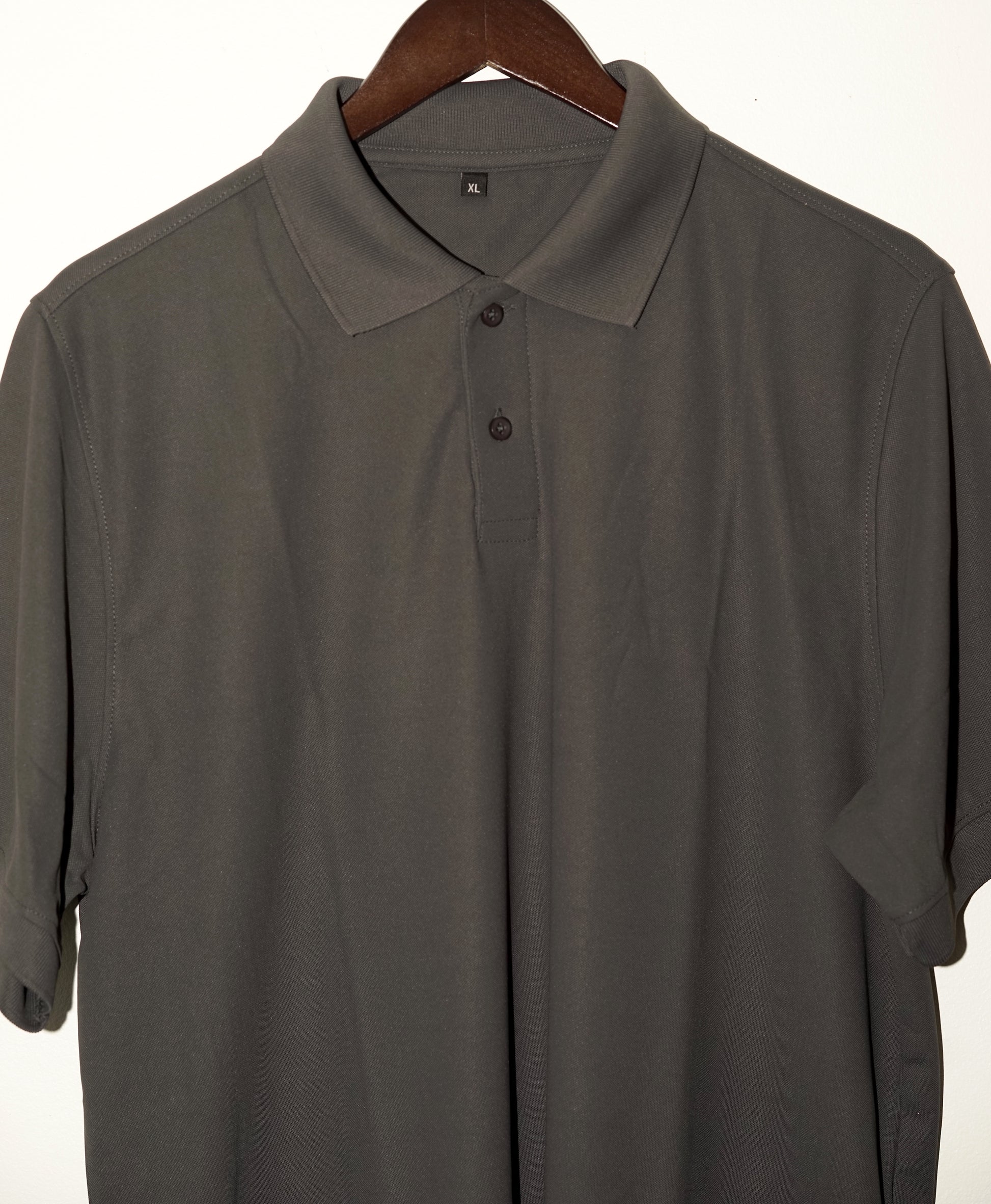 Gray polo shirt on a hanger against a white background