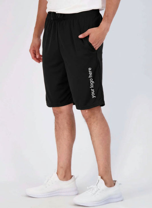 Person wearing black shorts and white sneakers on a light gray background